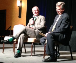 Jack Swarbrick (left) speaks with Jack Nolan (right) at the Shamrock Series luncheon while showing off a seriously on-point sock game.
