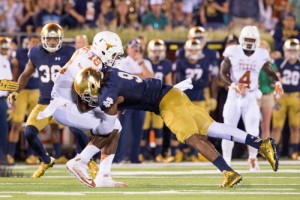 Longhorns quarterback Tyrone Swoopes (18) is tackled by Notre Dame Fighting Irish linebacker Jaylon Smith (9) in the second quarter. Credit: Matt Cashore-USA TODAY Sports 