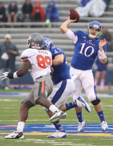 Kansas quarterback Dayne Crist throws as fullback Nick Sizemore fends off Oklahoma State defensive end Nigel Nicholas during the second quarter on Saturday, Oct. 13, 2012 at Memorial Stadium. (Nick Krug / Lawrence Journal-World)